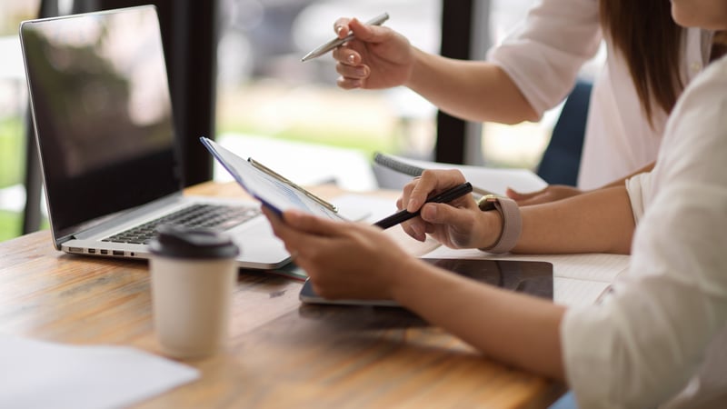 female hands holding pens and paper 