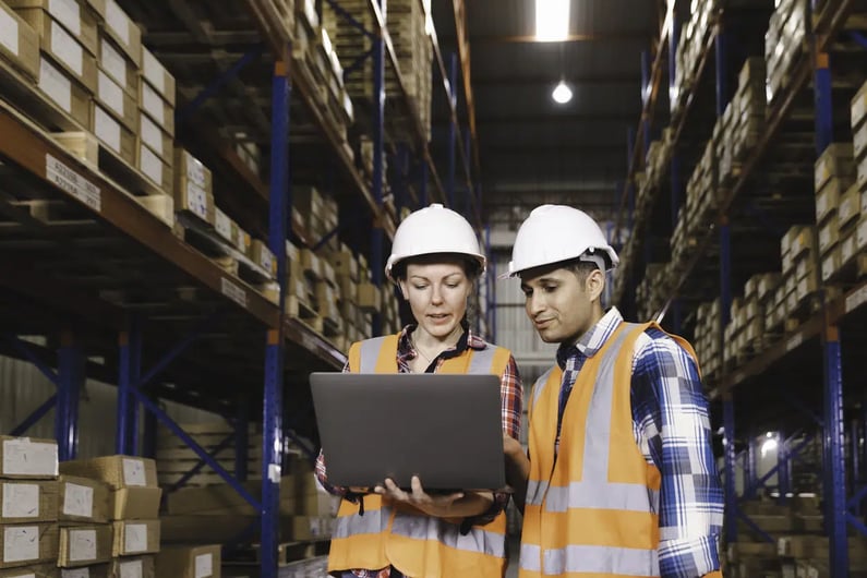 two warehouse workers on a computer